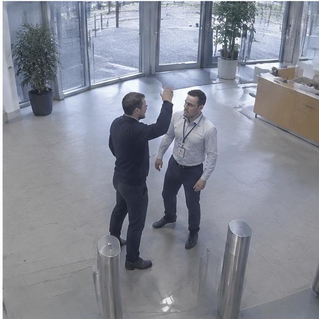 Staged tense interaction in corporate lobby — synthetic demonstration, not live